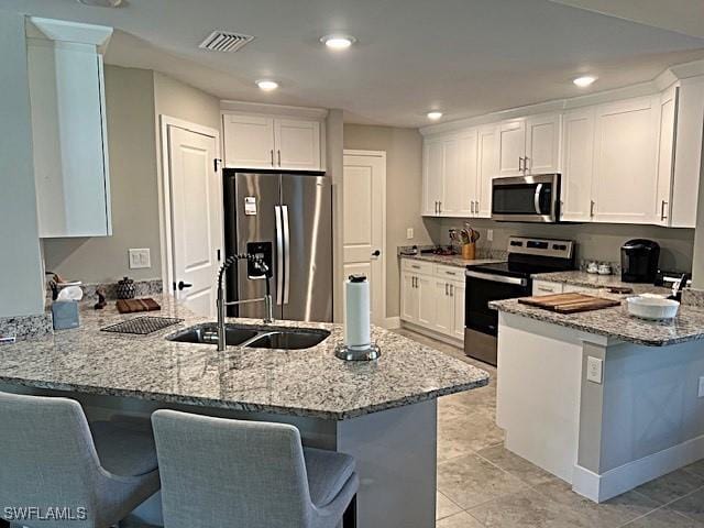 kitchen featuring white cabinetry, stainless steel appliances, and kitchen peninsula