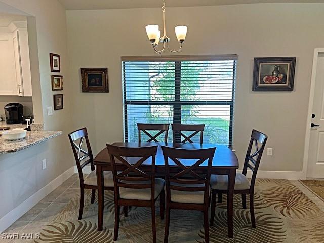 tiled dining area with a chandelier