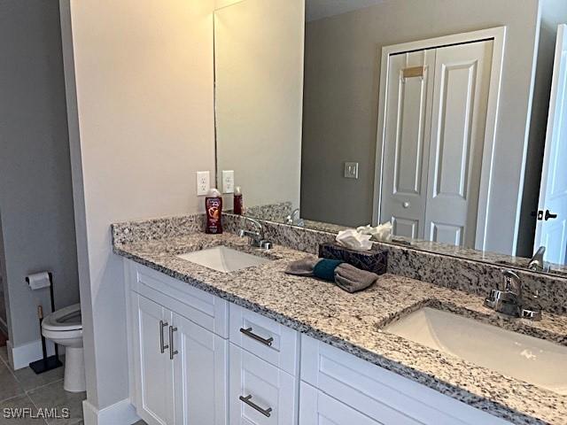 bathroom featuring vanity, tile patterned floors, and toilet