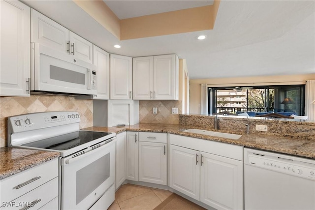 kitchen featuring sink, white appliances, and white cabinets