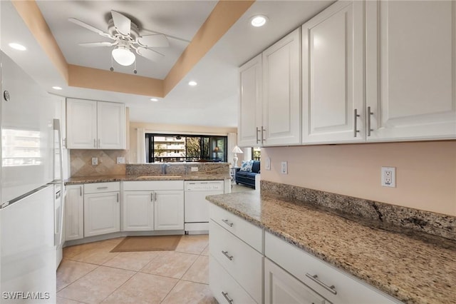 kitchen with sink, white appliances, a raised ceiling, and white cabinets