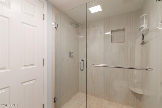 bathroom with a shower with door