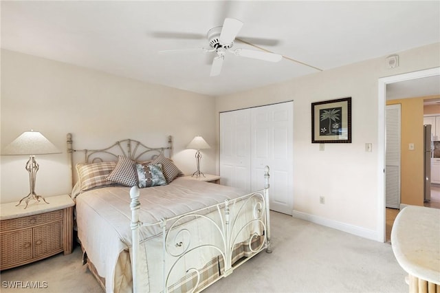 carpeted bedroom featuring ceiling fan and a closet