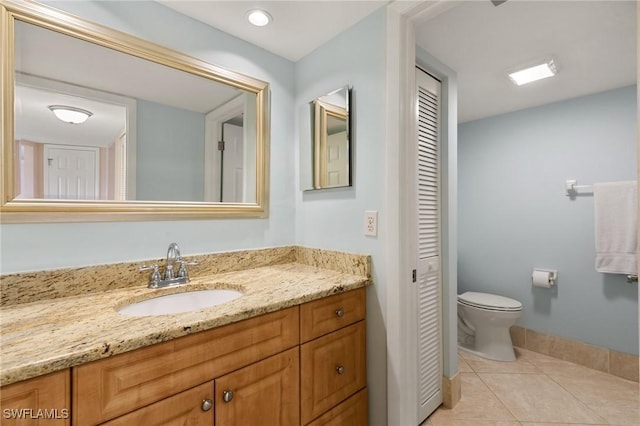 bathroom featuring vanity, tile patterned flooring, and toilet