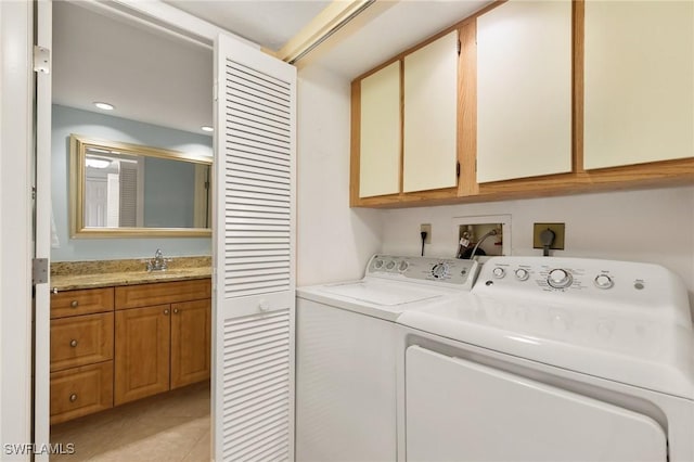 laundry area featuring cabinets, washer and clothes dryer, sink, and light tile patterned floors