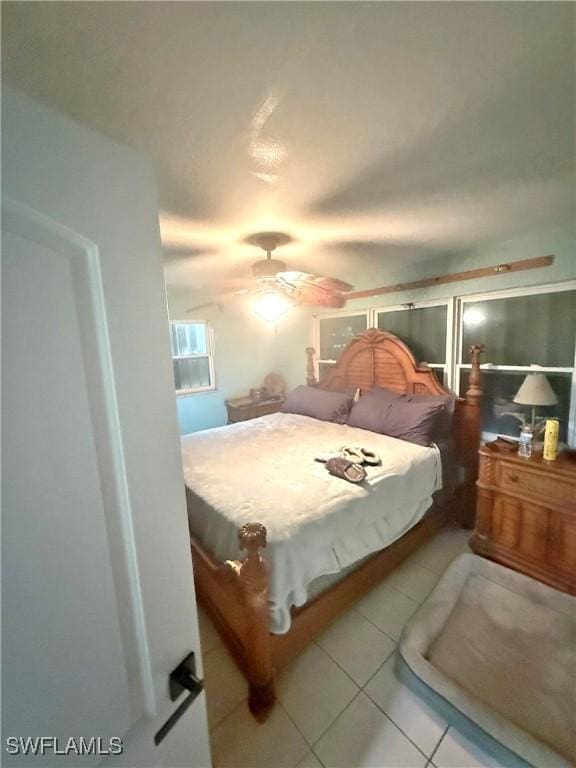 tiled bedroom featuring ceiling fan