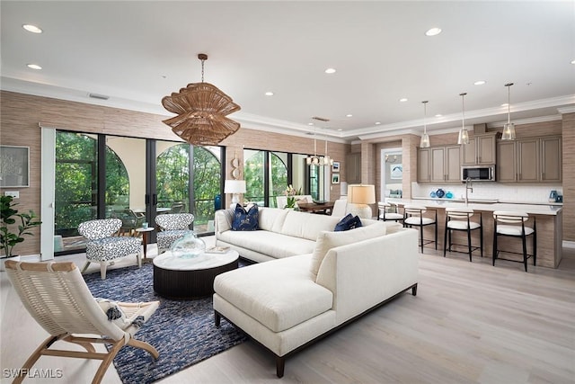 living room featuring light hardwood / wood-style floors, plenty of natural light, and ornamental molding