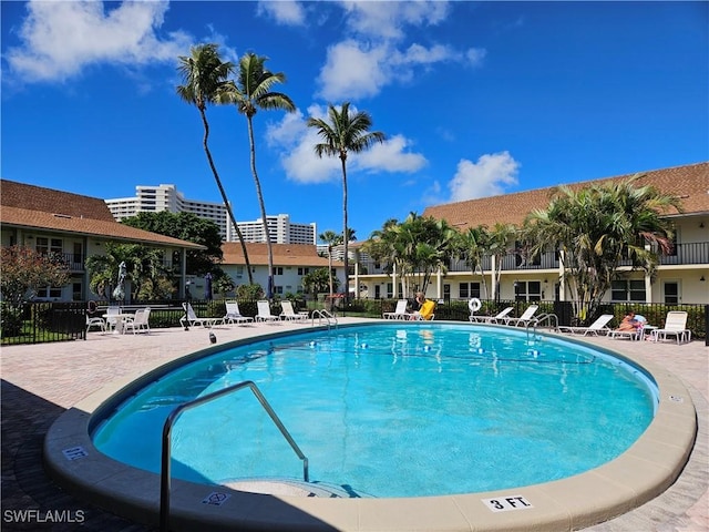 view of swimming pool featuring a patio and fence