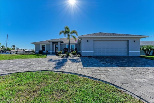 single story home featuring a garage and a front lawn