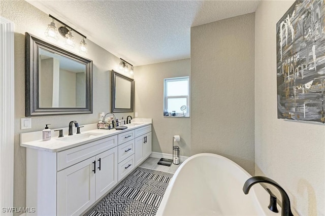 bathroom featuring vanity, a tub to relax in, wood-type flooring, and a textured ceiling