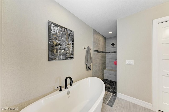 bathroom featuring independent shower and bath and a textured ceiling