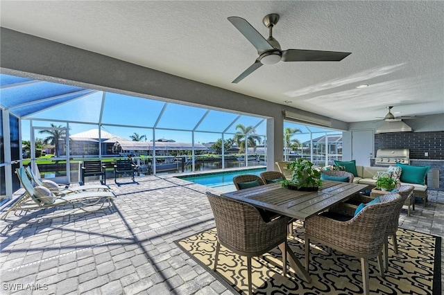 view of patio / terrace featuring ceiling fan, a lanai, area for grilling, and grilling area