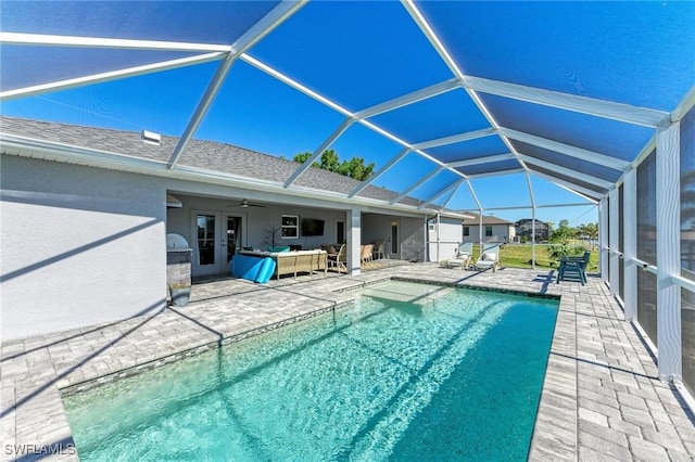 view of pool featuring a lanai, an outdoor hangout area, a patio, and ceiling fan