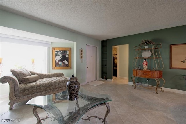 tiled living area with baseboards and a textured ceiling