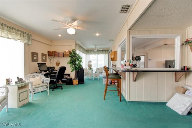 office space with visible vents, carpet floors, and ceiling fan