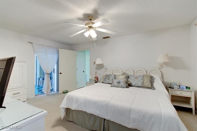 bedroom with visible vents, carpet floors, a textured ceiling, and ceiling fan