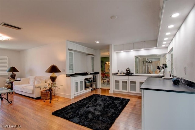 living area featuring light wood-style flooring, recessed lighting, visible vents, and baseboards