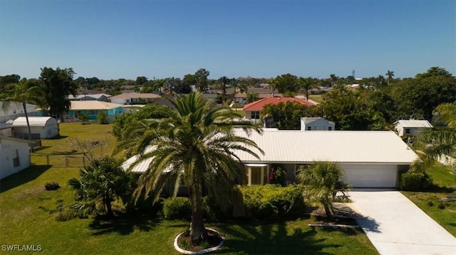 view of front of property with a front lawn, concrete driveway, fence, and a garage