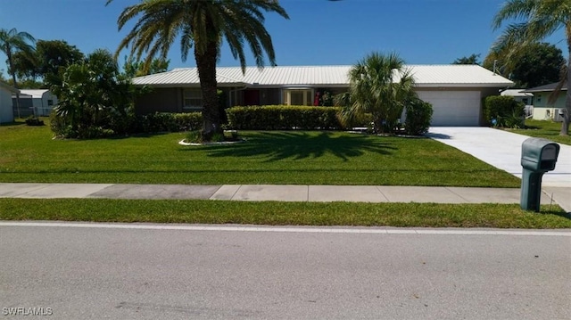 ranch-style house with concrete driveway, a garage, and a front yard