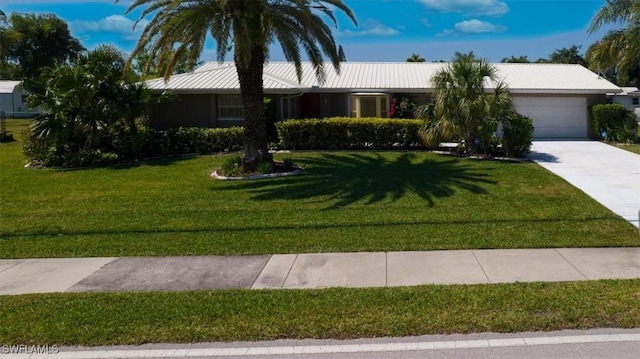 ranch-style house with a front lawn, an attached garage, and driveway