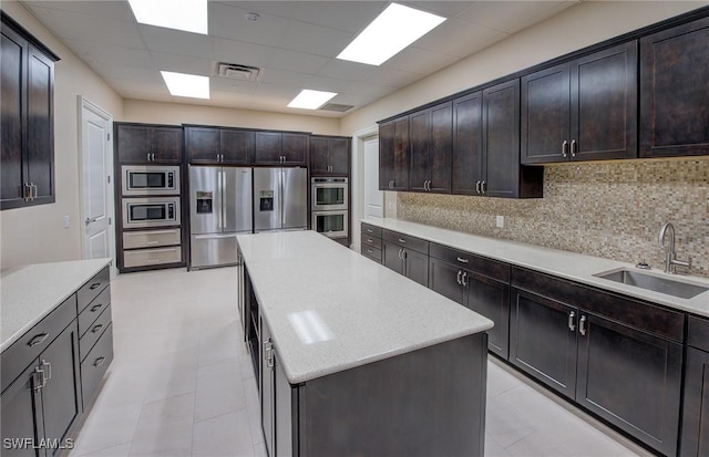 kitchen with a center island, stainless steel appliances, sink, and backsplash