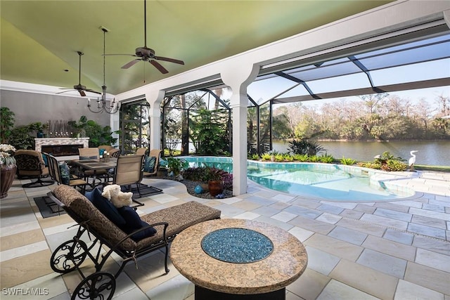 view of patio featuring a water view, ceiling fan, and glass enclosure