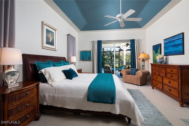 bedroom featuring ceiling fan, a tray ceiling, carpet, and access to outside