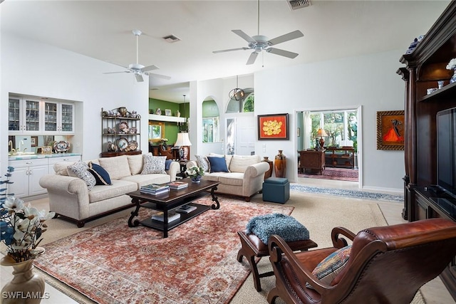 living room featuring ceiling fan and a high ceiling