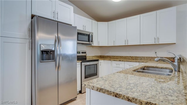 kitchen featuring light tile patterned flooring, white cabinetry, sink, light stone counters, and stainless steel appliances