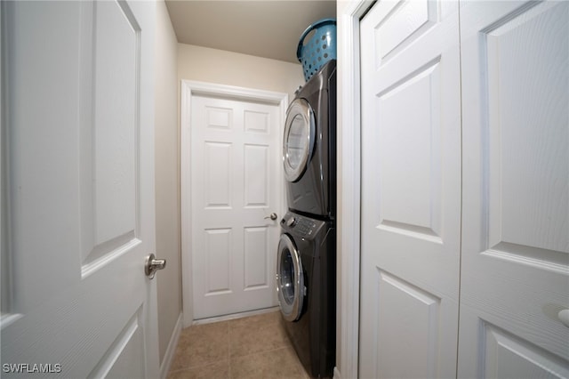 washroom with stacked washer / dryer and light tile patterned floors