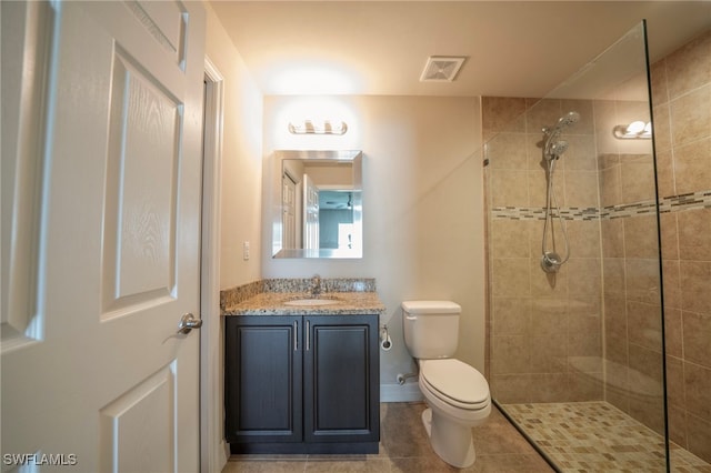 bathroom featuring tiled shower, vanity, toilet, and tile patterned floors