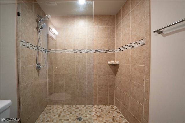 bathroom featuring toilet and a tile shower