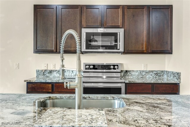 2628 Manzilla Ln, Cape Coral, FL 33909 - kitchen featuring appliances with stainless steel finishes, dark brown cabinets, and light stone counters