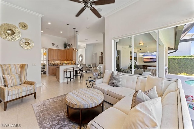 living room featuring light tile patterned floors, ornamental molding, and ceiling fan