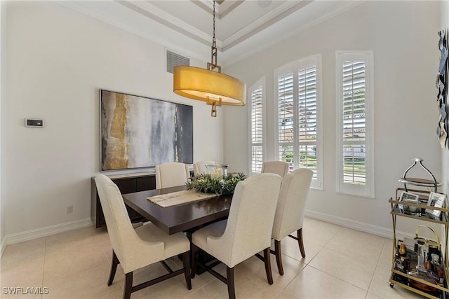 tiled dining space with ornamental molding, plenty of natural light, and a raised ceiling