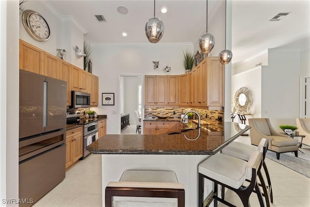 kitchen featuring sink, a breakfast bar area, hanging light fixtures, kitchen peninsula, and stainless steel appliances