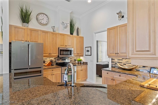 kitchen featuring tasteful backsplash, dark stone countertops, stainless steel appliances, crown molding, and light brown cabinets