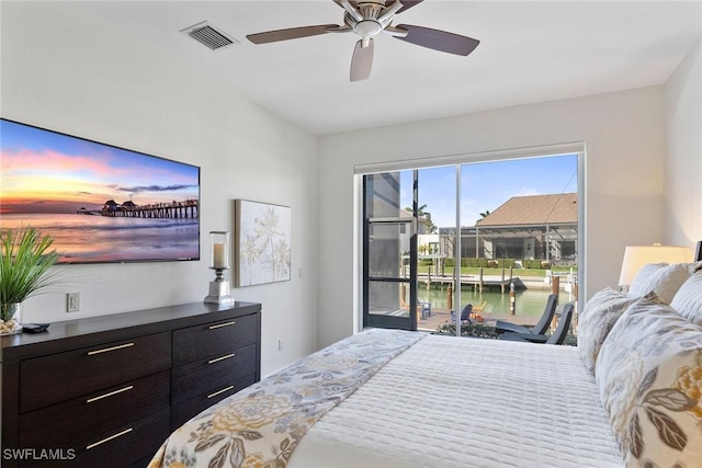 bedroom with a water view, ceiling fan, and access to exterior