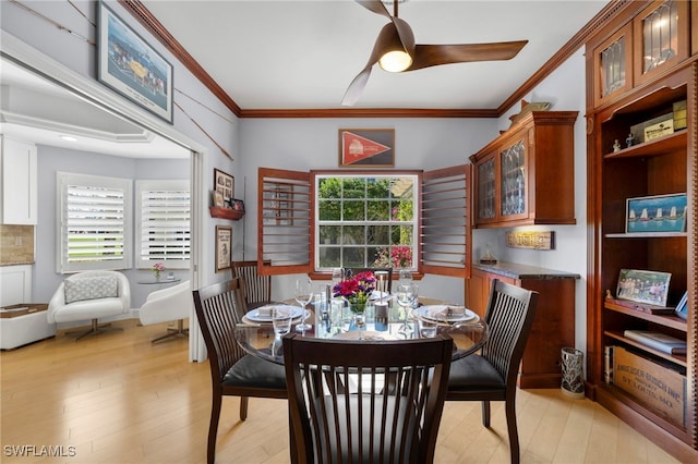 dining room with light wood-type flooring, a wealth of natural light, ceiling fan, and ornamental molding