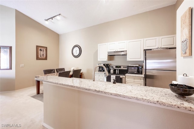 kitchen featuring white cabinets, light stone countertops, stainless steel appliances, under cabinet range hood, and lofted ceiling