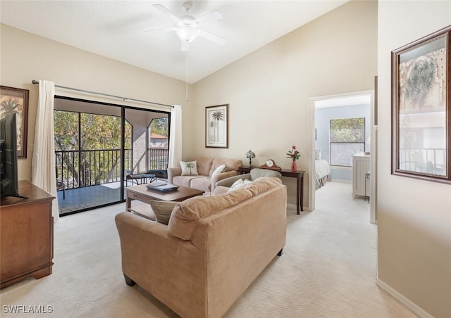 living area featuring light colored carpet, high vaulted ceiling, ceiling fan, and baseboards