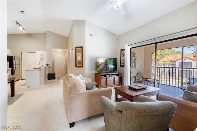 living area featuring a ceiling fan, high vaulted ceiling, light colored carpet, and visible vents