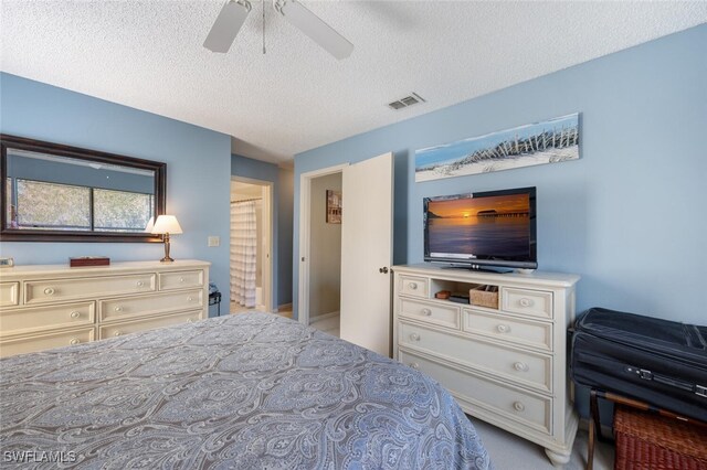 bedroom with a textured ceiling, visible vents, and ceiling fan