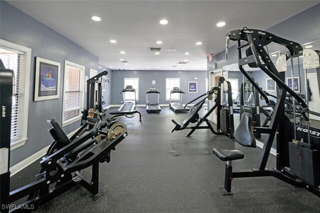 gym featuring baseboards, visible vents, a wealth of natural light, and recessed lighting