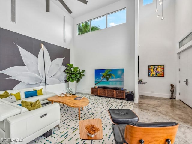 living room with a towering ceiling and ceiling fan