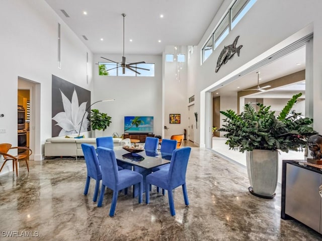 dining space with ceiling fan and a high ceiling