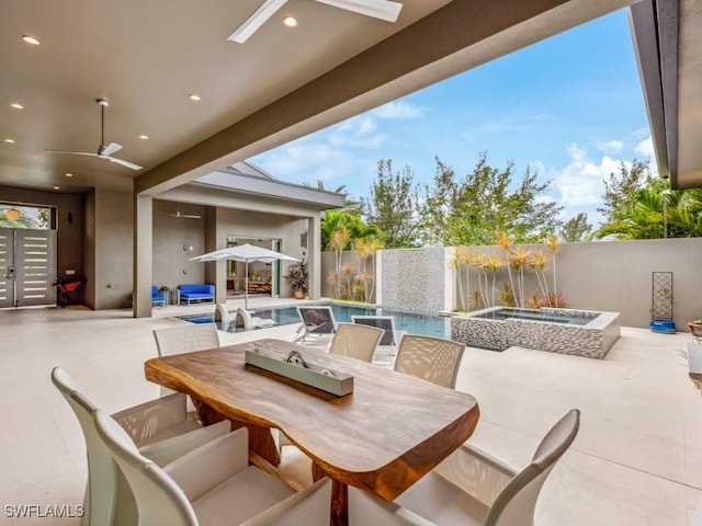 view of patio / terrace with ceiling fan and a pool with hot tub