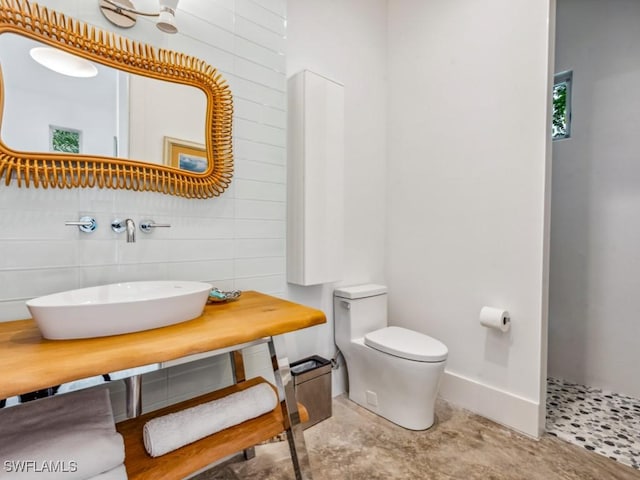 bathroom with sink, decorative backsplash, and toilet