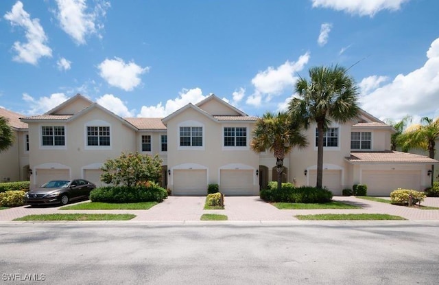 1172 Oxford Ln Unit 27, Naples, FL 34105 - multi unit property featuring a garage, decorative driveway, and stucco siding