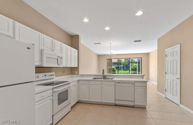 kitchen featuring a peninsula, white appliances, a sink, white cabinetry, and light countertops